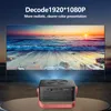 A projector is projecting an image of a sunset beach scene onto a large screen. The projector is placed on a table in the foreground. Produktbild-Vorschau