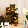 Three LED candles with fairy lights inside glass cylinders, placed on a decorative box and a wooden coaster, with USB cables and a remote control in the foreground. Produktbild-Vorschau