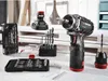 A collection of power tools and accessories, including a cordless drill, drill bits, and a bit set, arranged on a workbench. Produktbild-Vorschau