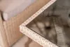Close-up of the corner of a wicker-style outdoor furniture set, showing the woven texture and a glass tabletop. Náhľad obrázku produktu