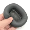 A hand holding a gray ear pad for headphones. Produktbild-Vorschau