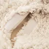 A close-up view of a beige sheepskin cover for a hot water bottle, showing the texture of the material and a velcro closure. Podgląd zdjęcia produktu