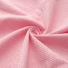 A close-up view of pink corduroy fabric, showing its ribbed texture and soft folds. Náhled obrázku produktu