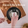 A hand is cleaning a frying pan with a sponge, with text overlays about the product's features. Náhled obrázku produktu