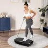 A woman is exercising on a vibration plate in a room. Voir les images du produit