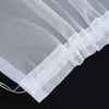 A close-up view of the ruffled edge of a white sheer curtain. Produktbild-Vorschau