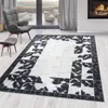 A living room scene with a rug, armchair, and fireplace. Produktbild-Vorschau