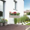 A modern planter on a wooden deck next to a white house. Produktbild-Vorschau