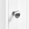 A close-up shot of a silver doorknob on a white cabinet door. Podgląd zdjęcia produktu