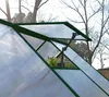 Close-up view of an open automatic vent on a greenhouse, with plants visible inside. Náhled obrázku produktu
