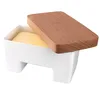 A white butter dish with a wooden lid, containing butter. Podgląd zdjęcia produktu
