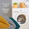 A washing machine with blankets in the foreground and decorative items on top. Náhľad obrázku produktu
