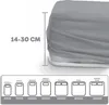 A diagram showing different mattress sizes with their corresponding dimensions, overlaid on a close-up of a gray fitted sheet on a mattress. Produktbild-Vorschau