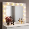 A white vanity dresser with a lighted mirror and various cosmetic products on top. Voir les images du produit