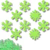 A collection of green snowflake-shaped confetti scattered on a white background. Podgląd zdjęcia produktu