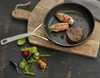 A frying pan with food on a wooden cutting board, surrounded by fresh ingredients. Produktbild-Vorschau