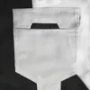 A close-up view of a white cargo pocket on a pair of black and white work pants. Produktbild-Vorschau