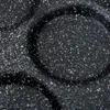 A close-up view of a speckled black frying pan surface. Produktbild-Vorschau