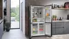 A modern kitchen with an open refrigerator showcasing its contents, with a view of an outdoor patio through a large window. Náhľad obrázku produktu