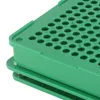 A close-up view of a green capsule filling tool. Voir les images du produit