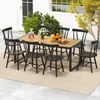 An outdoor dining set with a wooden table and black chairs on a patio. Podgląd zdjęcia produktu