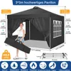 A woman is holding a folded tent bag next to a black pop-up pavilion. The pavilion has windows and is set up on a gray surface. Voir les images du produit