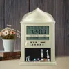 A digital Islamic clock with an Arabic design, placed on a wooden surface next to a vase of flowers and books. Produktbild-Vorschau