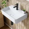 A modern white ceramic wall-mounted sink with a black faucet and a small potted plant on the side, set against a tiled wall. Anteprima dell’immagine prodotto