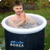 A man is sitting in an inflatable ice bath outdoors. Produktbild-Vorschau