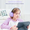 A young girl wearing headphones with cat ears is looking at a tablet. Podgląd zdjęcia produktu