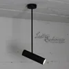 A black pendant light hangs from a white ceiling against a textured white wall. Podgląd zdjęcia produktu