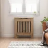 A radiator cover in a living room setting, placed in front of a window with blinds. Náhľad obrázku produktu