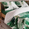 A close-up view of a bed with green and white banana leaf patterned bedding. Podgląd zdjęcia produktu
