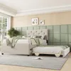 A bedroom scene with a beige upholstered bed and a pull-out trundle bed. Anteprima dell’immagine prodotto