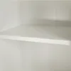 A close-up view of a white shelf inside a cabinet or closet. Náhled obrázku produktu