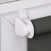 A close-up view of a white roller blind attachment on a window frame, with a dark gray roller blind visible. Produktbild-Vorschau