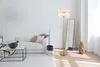 A modern living room with a white sofa, coffee table, floor lamp, and mirror. Náhľad obrázku produktu