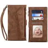 A brown leather wallet with a wrist strap and card slots, shown open to display the interior and a photo of a baby. Produktbild-Vorschau