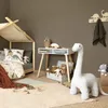 A child's bedroom with a bed, desk, and toys, featuring a large plush dinosaur. Produktbild-Vorschau