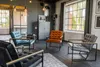 A modern living room with four armchairs arranged around a rug, with large windows in the background. Produktbild-Vorschau