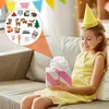 A young girl wearing a yellow dress and a party hat is sitting on a couch, holding a gift. A magnified inset shows various craft supplies and felt animal figures. Produktbild-Vorschau