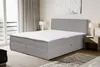 A modern bedroom setting with a large box spring bed. Produktbild-Vorschau
