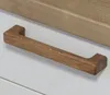 A close-up shot of a wooden drawer pull on a white surface. Produktbild-Vorschau