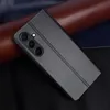A black flip cover phone case with a camera cutout is shown diagonally on a dark background with some brown and dark blue elements. Produktbild-Vorschau
