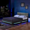 A modern bedroom scene at night with a city skyline visible through a window, featuring a bed with LED lighting. Produktbild-Vorschau