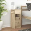 A bedside table next to a bed, with a plant and a lamp on it. Voir les images du produit