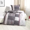 A neatly made bed with a grey, white, and red patterned duvet and pillow. Produktbild-Vorschau