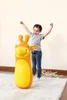 A young girl is happily playing with an inflatable giraffe punching bag in a room. Produktbild-Vorschau