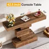 A wooden console table with a modern, stacked design is shown against a white wall. It is decorated with a bouquet of flowers and a magazine on the left, and a bottle of liquor on a tray on the right. Dimensions are indicated by text overlays. Anteprima dell’immagine prodotto