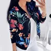 A woman is taking a mirror selfie wearing a floral bomber jacket. Anteprima dell’immagine prodotto